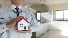 作業員が家の模型を持っている