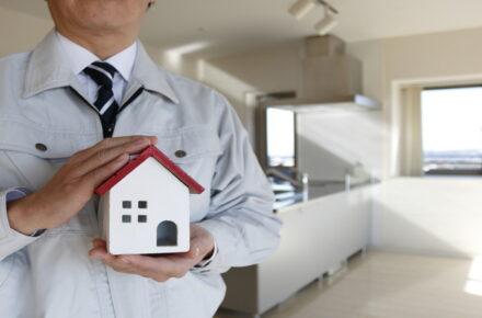 作業員が家の模型を持っている