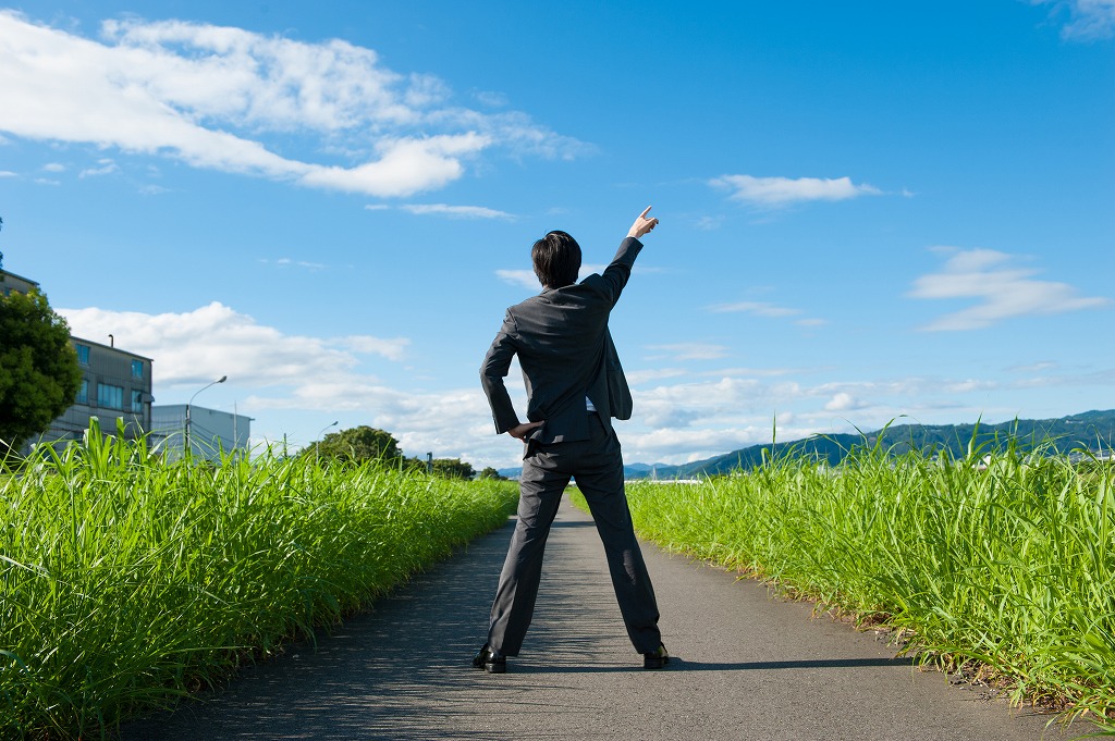 後ろ姿の男性、空に指さしている