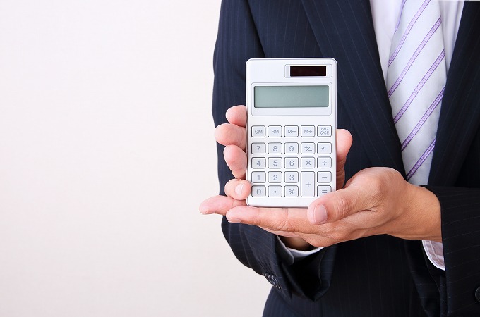 電卓を持っているスーツの男性